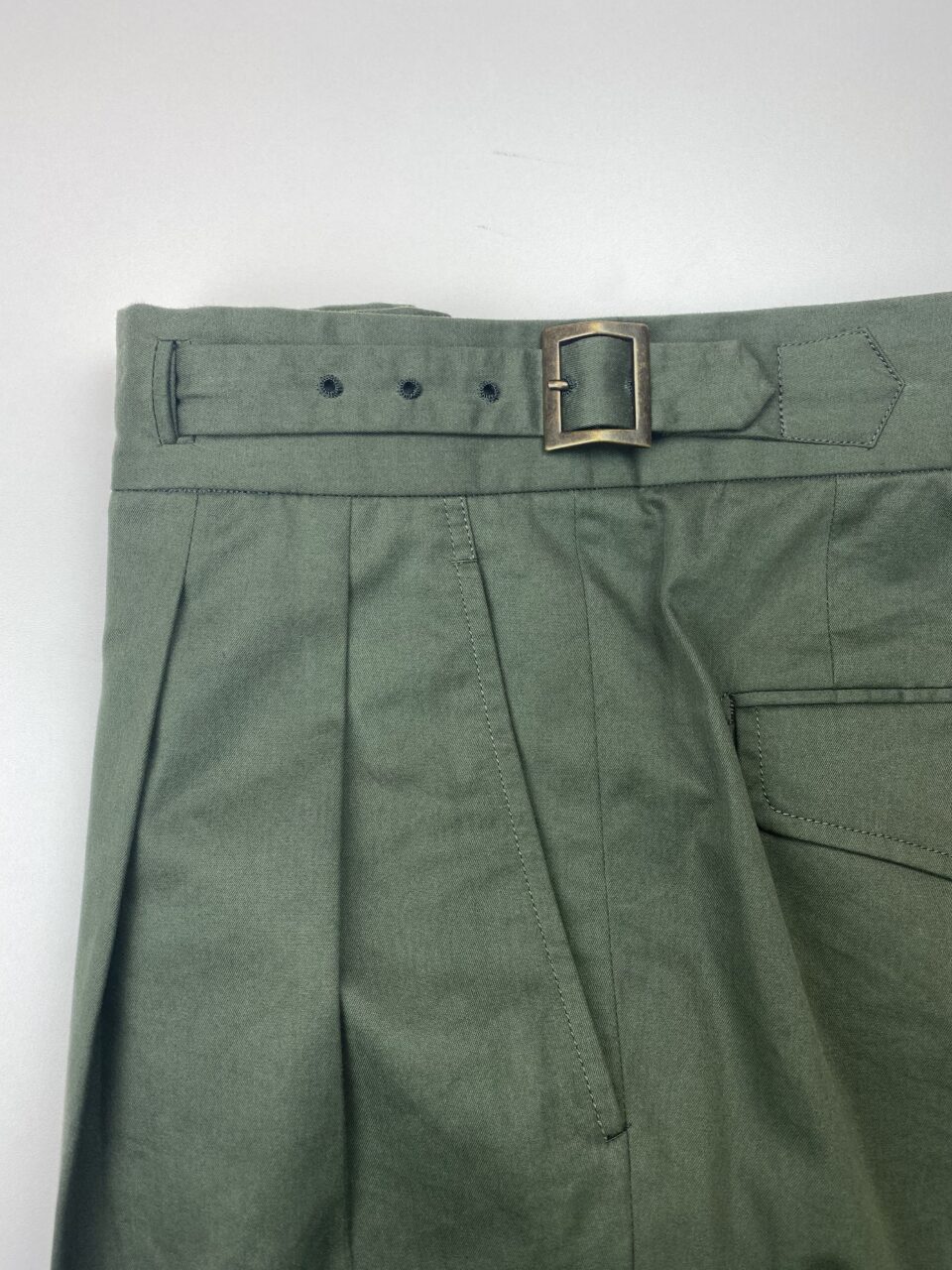 Close-up of waistband with pleats and buckle details of Green Cotton Gurkha Trousers - custom suits nyc bespoke tailor midtown, noho