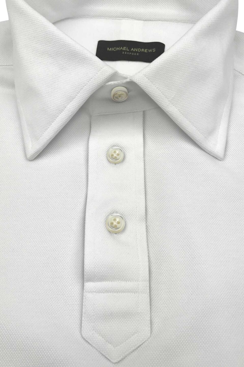 (product) White Pique Short Sleeve Polo Shirt, close-up of collar and buttons - custom suits nyc bespoke tailor midtown, noho