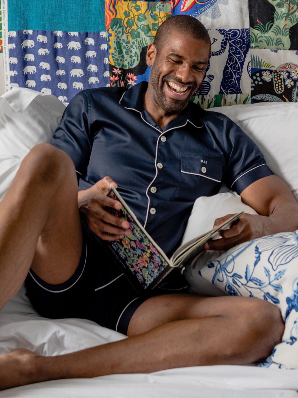(product) Navy Pajama Shorts, worn by a model relaxing with a book