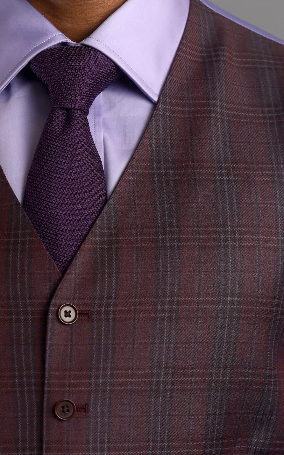 Maroon plaid suit vest styled with a lilac shirt and dark purple tie