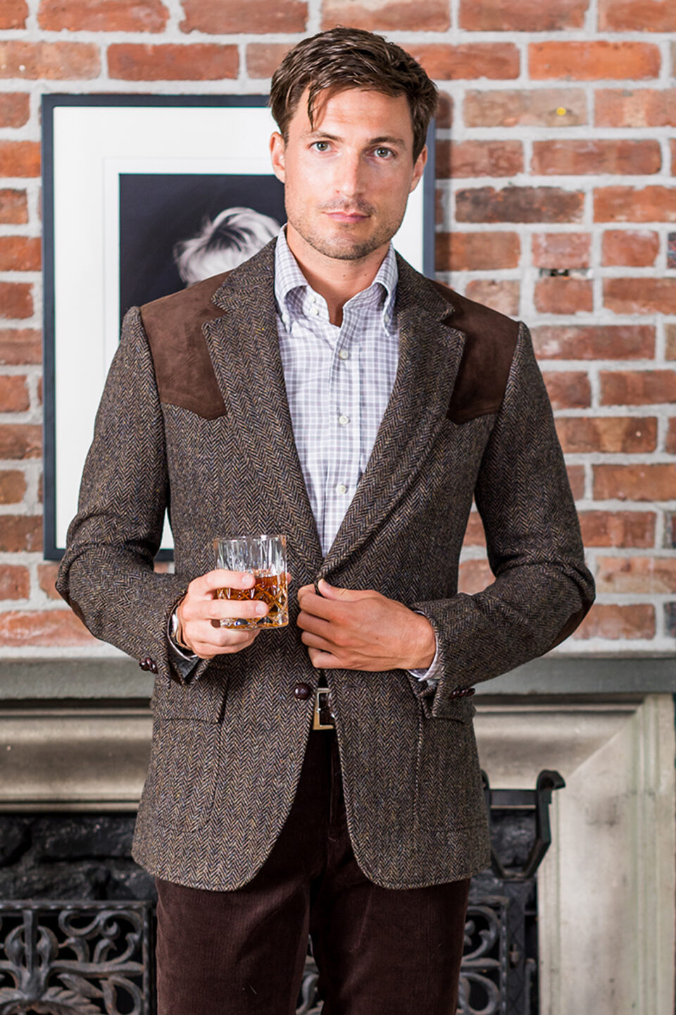 (product) Brown Herringbone Western Jacket, styled with a checked shirt, holding a drink