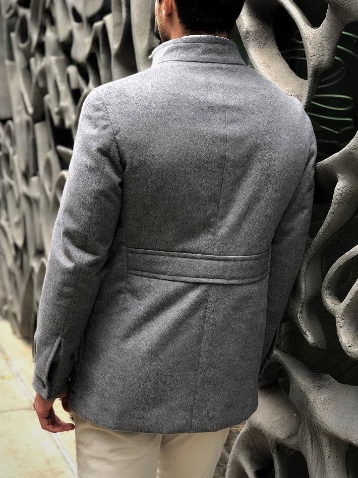 Back view of a light grey field jacket with down backing, showing the structured back design