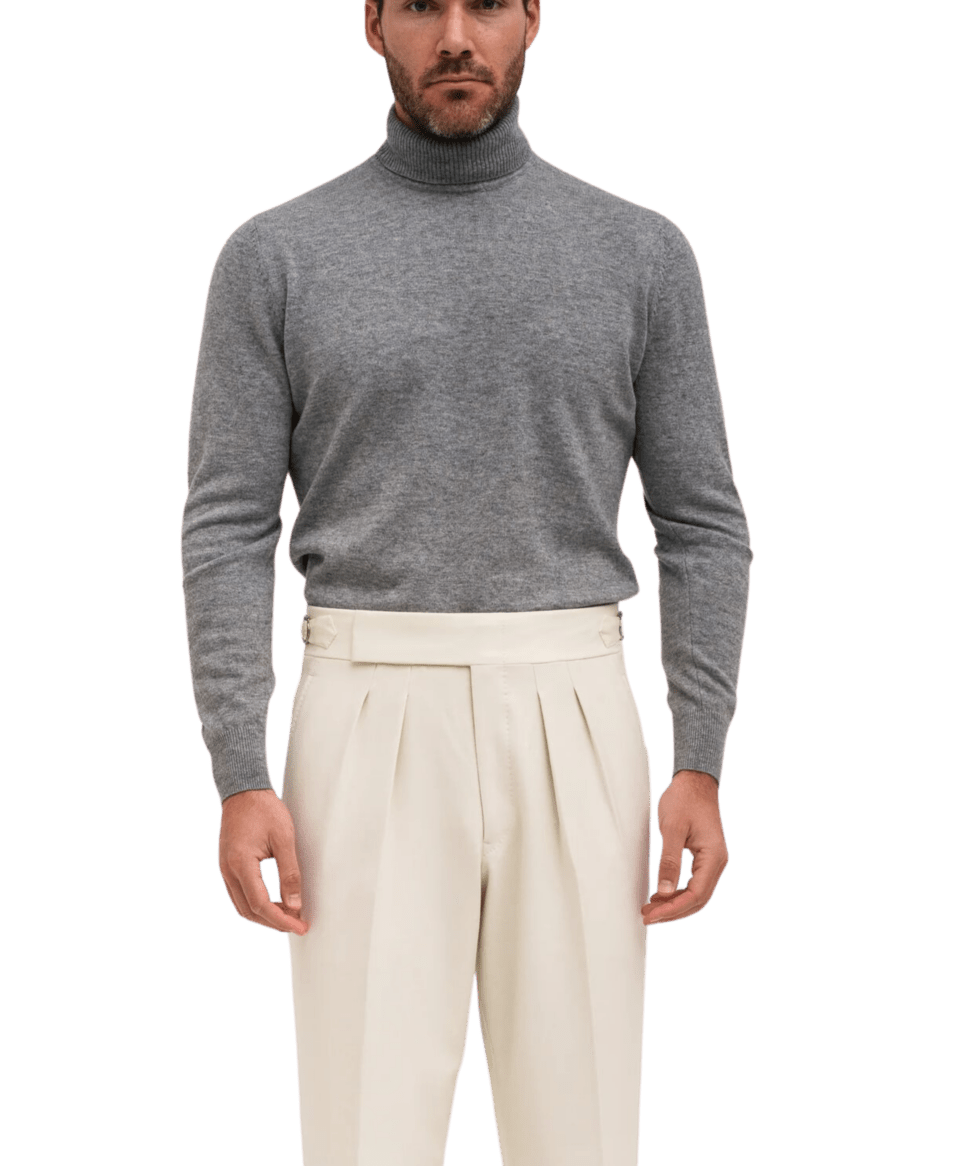 Model in a husky cashmere turtleneck paired with cream pleated trousers