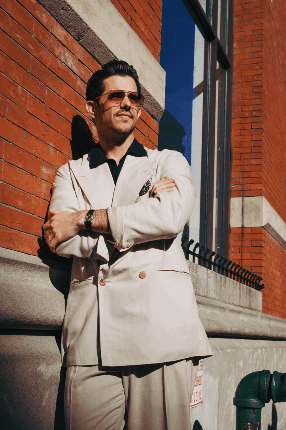Cory wearing a beige double-breasted suit with wide peak lapels and a dark open-collar shirt