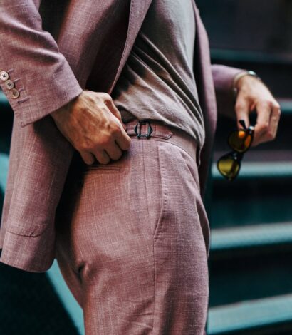 Close-up of a dusty rose blend suit with side adjuster detail, paired with a casual tee