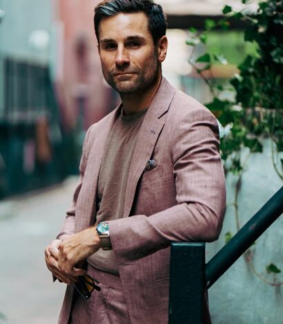 Shane in a dusty rose blend suit and taupe crewneck tee, styled with a pocket square and watch