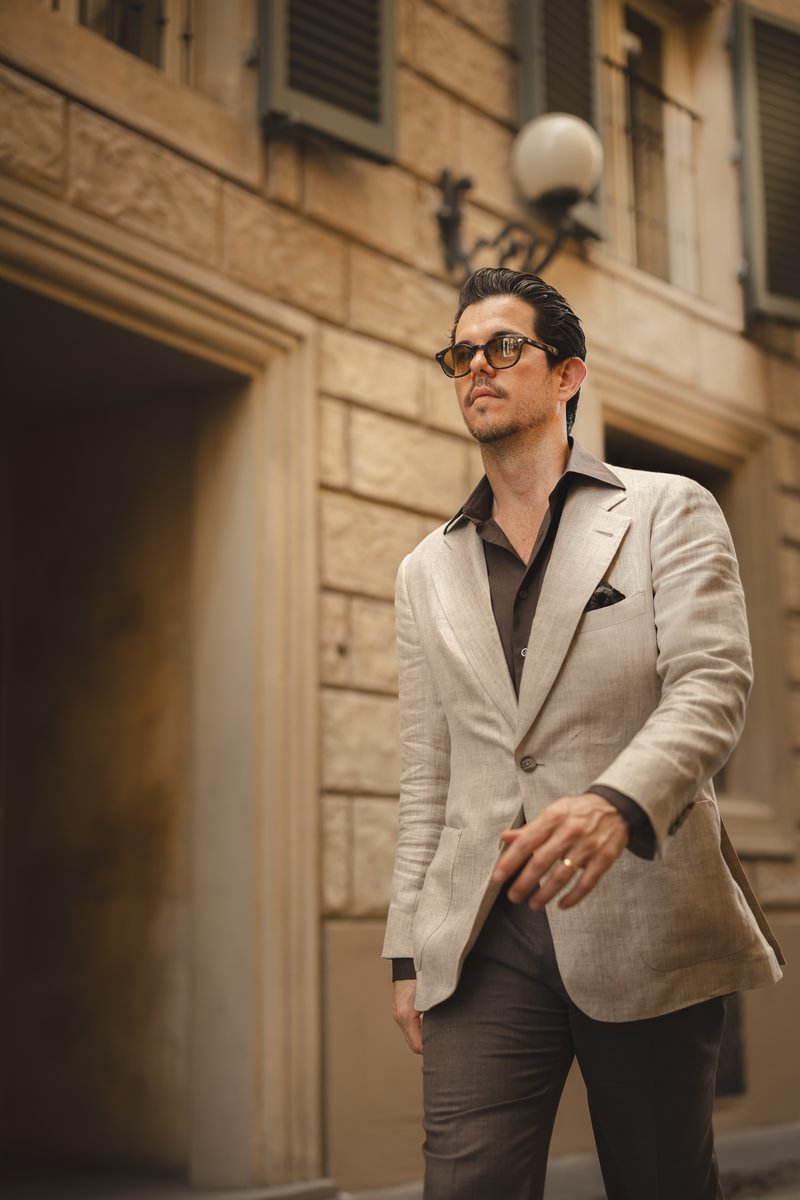 Cory walking in a tan linen sport coat over a brown shirt and trousers