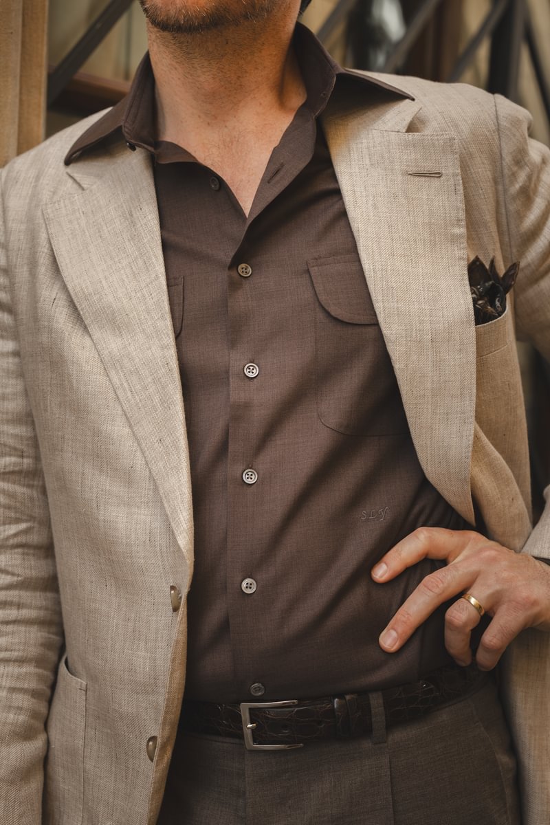 Close-up of a tan linen sport coat layered over a brown dual-pocket shirt